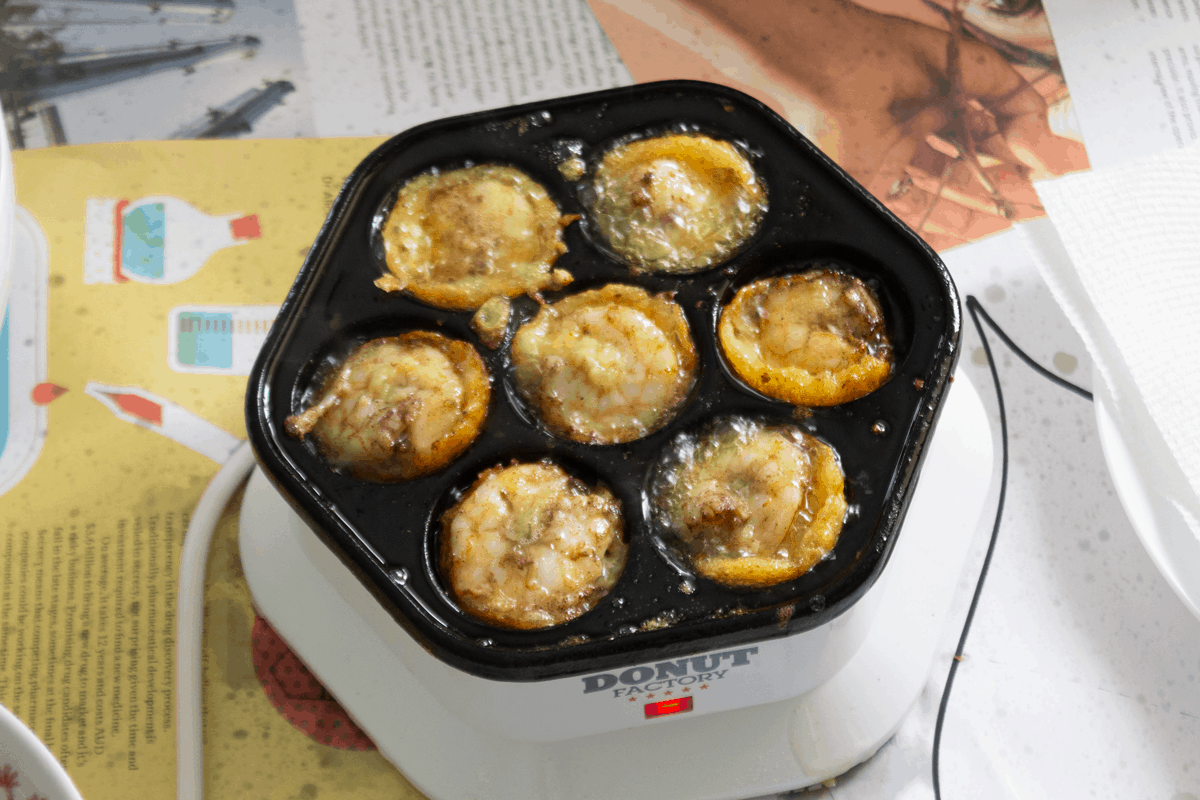 Banh khot cooked in a donut hole maker.