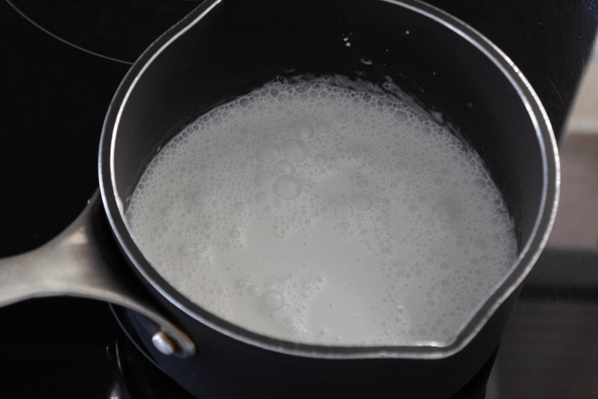 Coconut milk boiling in a saucepan.