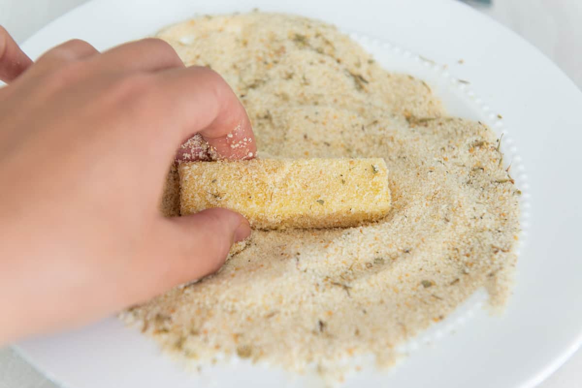 Breading a piece of cheese with dry bread crumbs