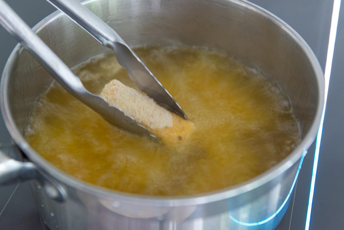 Deep frying a mozzarella cheese stick in tallow