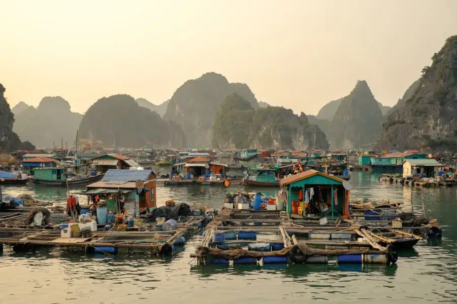 House and fishing boat in Cay Beo floating village on sunset, Ha Long