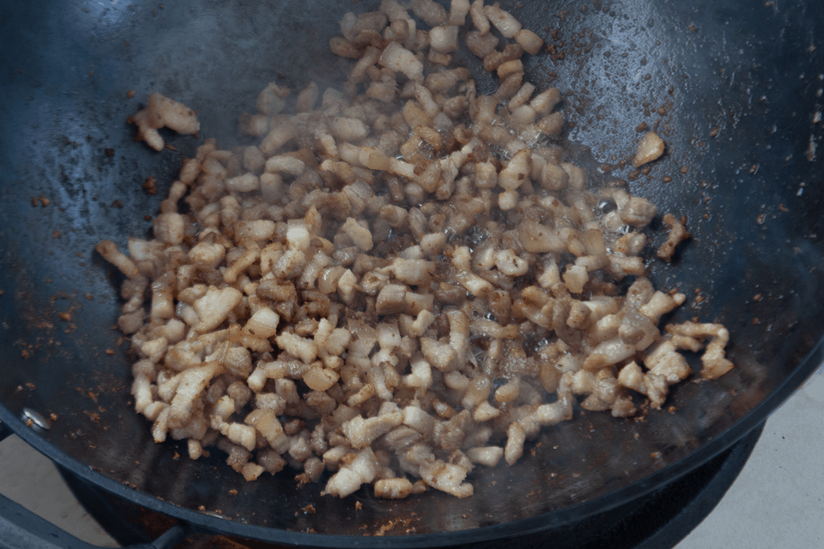 Pork belly pieces in a wok.