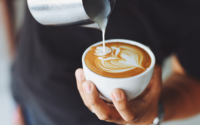 Close up of someone pouring latte art.