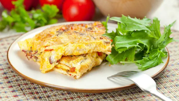 Đĩa ăn với omelette và rau xà lách.