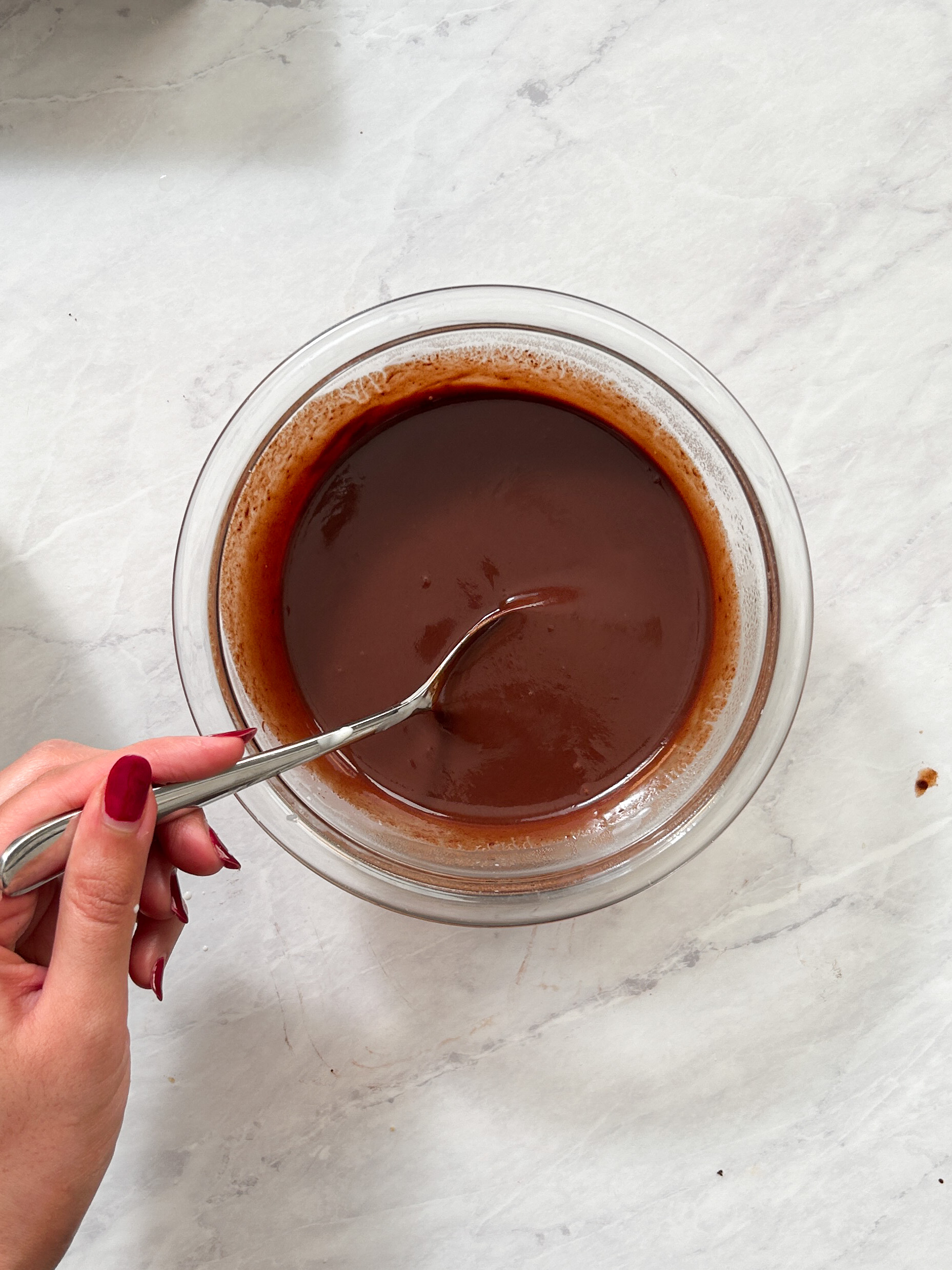 smooth and shiny chocolate ganache in a small glass bowl