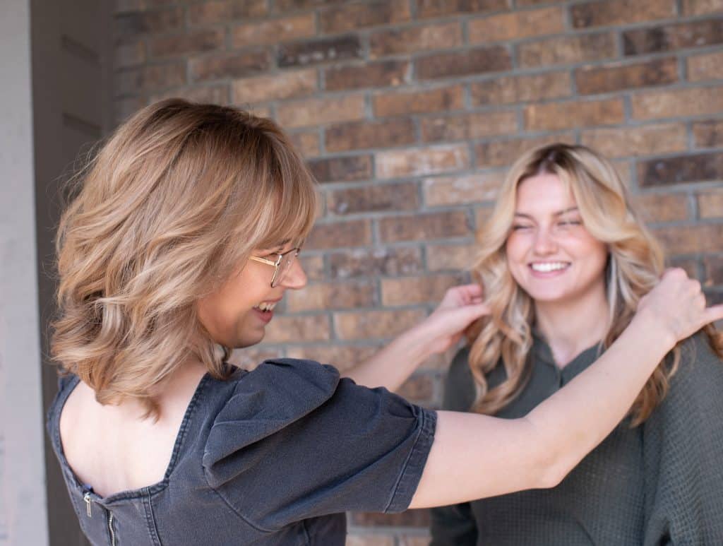 Stylist and client smiling after service